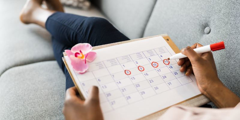 Woman on coach with her mentrual calendar